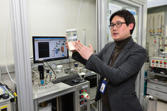 윤창원 KIST 수소·연료전지연구단장이 수소 저장·운송에 쓰이는 LOHC(액상유기물수소저장체)와 관련 장치를 설명하고 있다.  KIST 제공